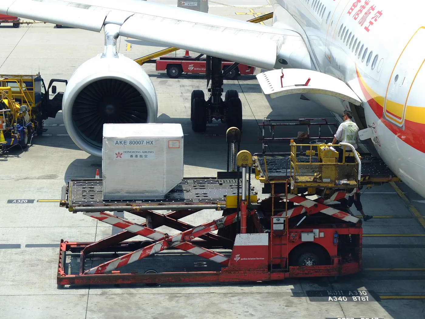 An aircraft cargo loader in operation, shown as an air-freight reference