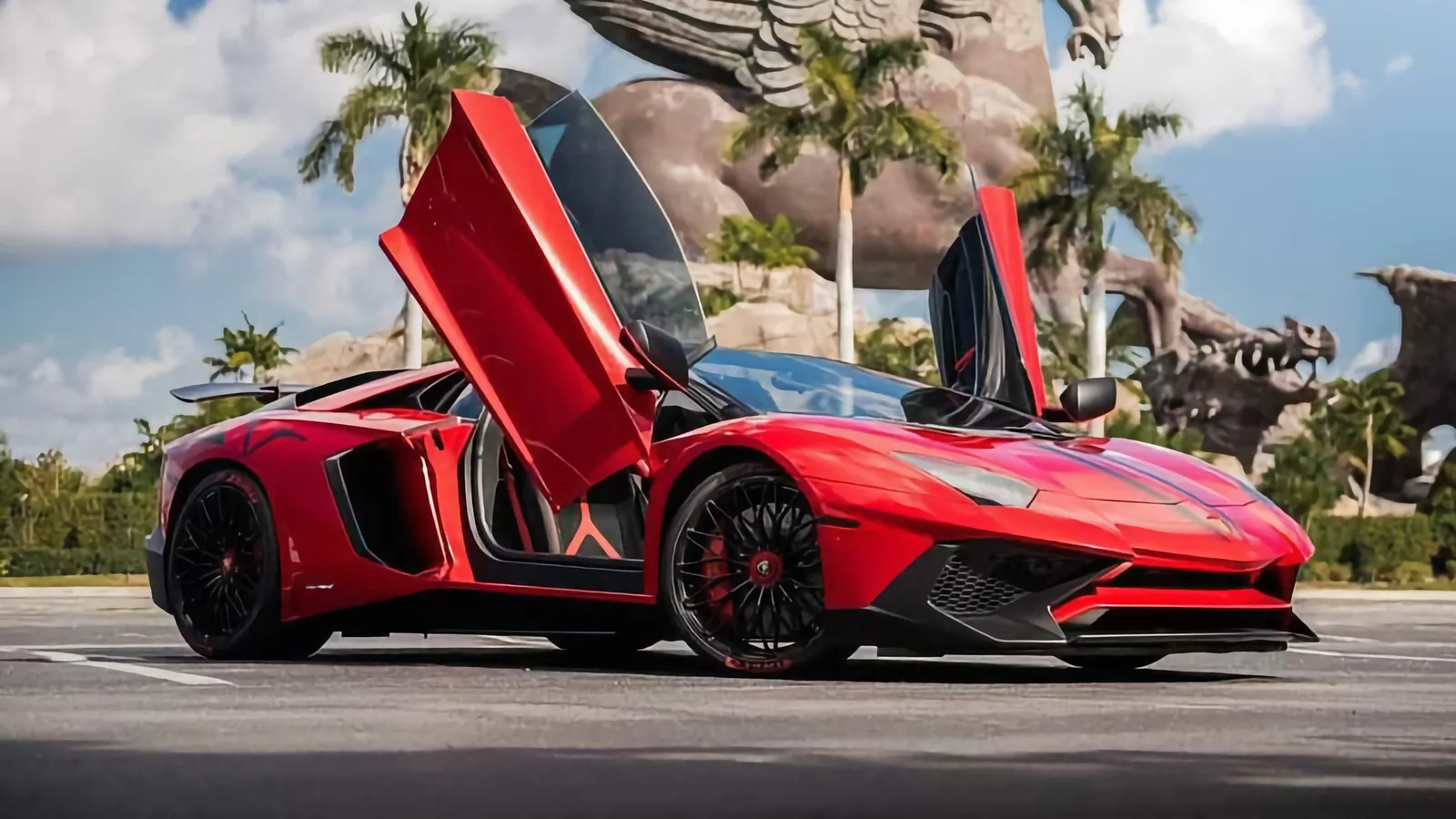 Red Lamborghini Aventador beside a Pegasus sculpture, Pugachev Luxury Car Rentals — best exotic car rental Miami guide