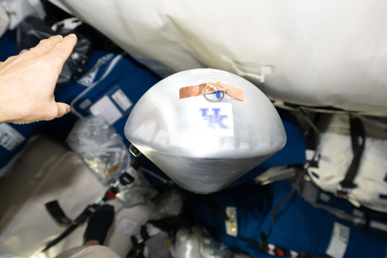 A KREPE-3 experimental reentry capsule photographed inside a Cygnus cargo spacecraft