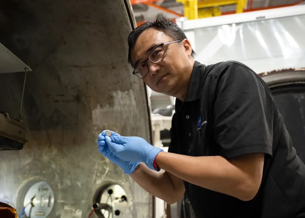 Yi Lin holding a SPEARS prototype battery after testing at NASA Langley