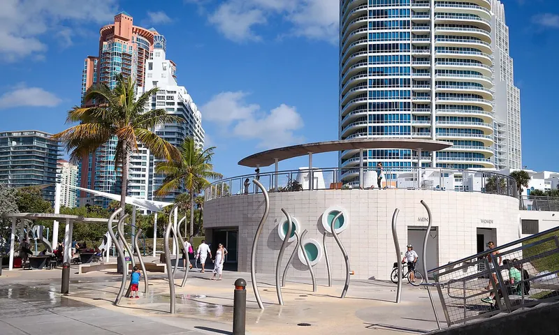 Pasarela bordeada de palmeras e instalaciones públicas en South Pointe Park en Miami Beach
