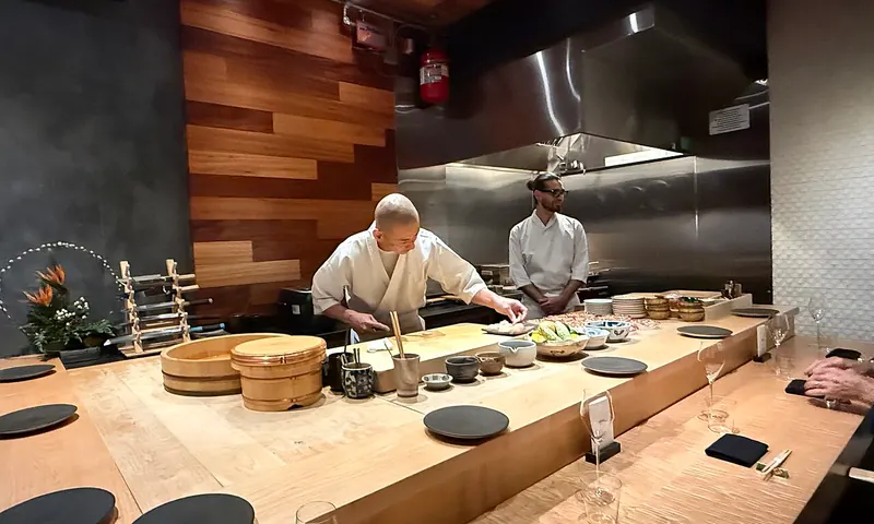 Chefs preparando una comida omakase en el mostrador de Hiden en Miami