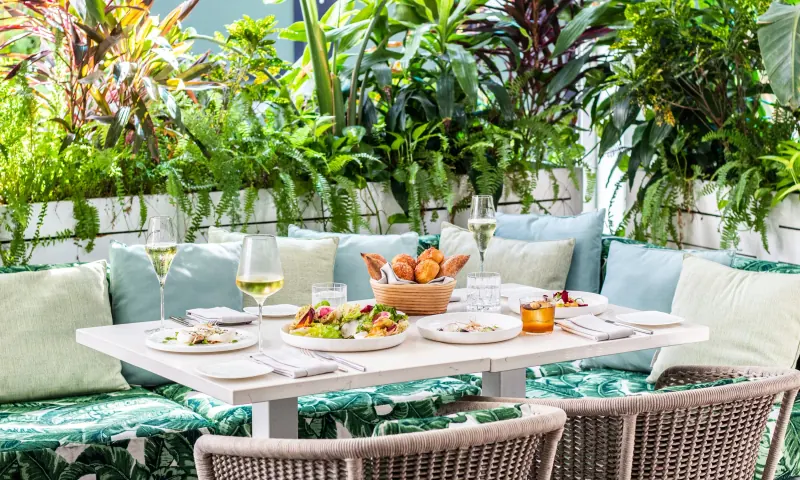 Mesa de patio y platos en Le Jardinier Miami