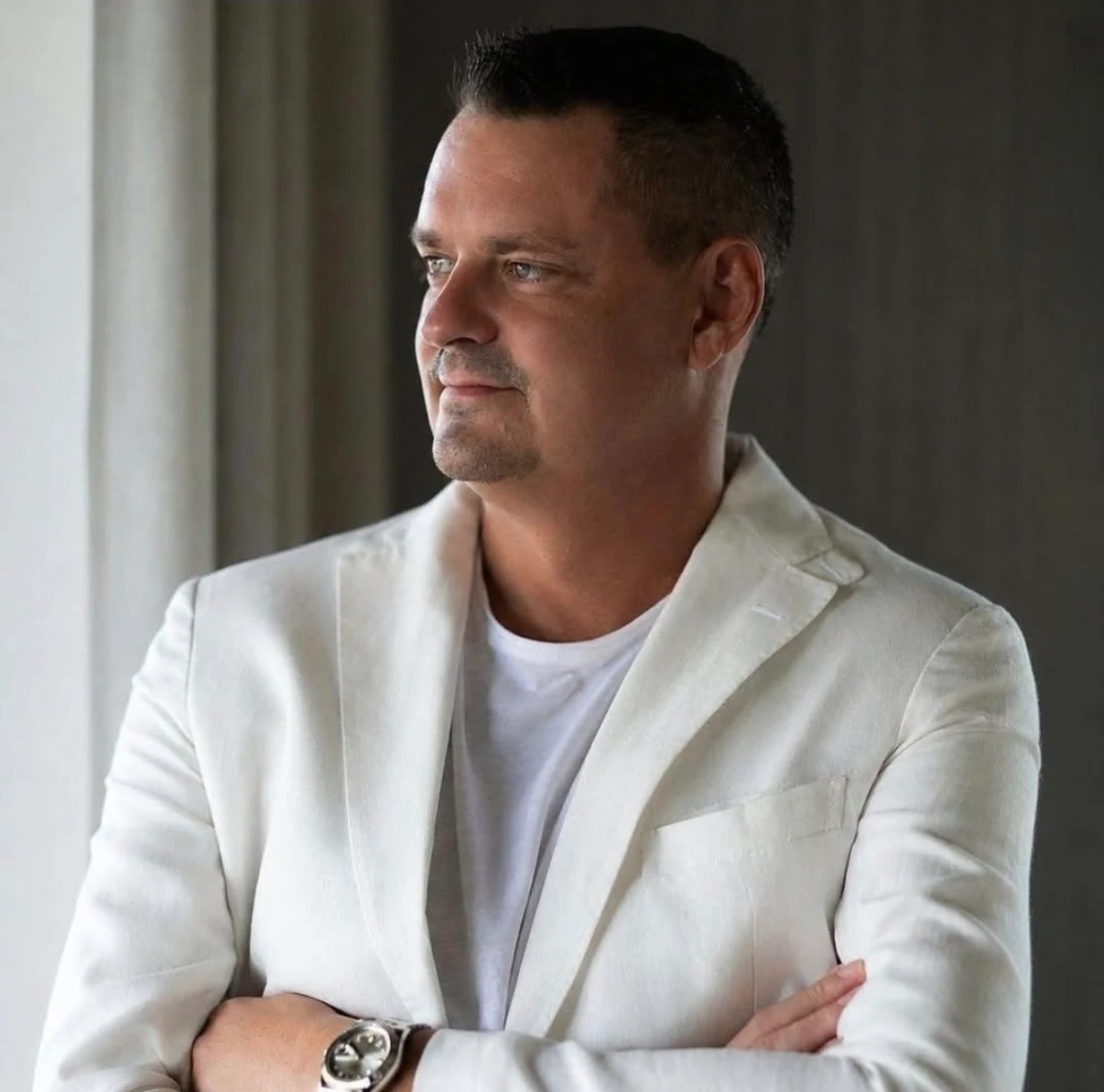 Oleg Semenov con chaqueta blanca junto a una ventana