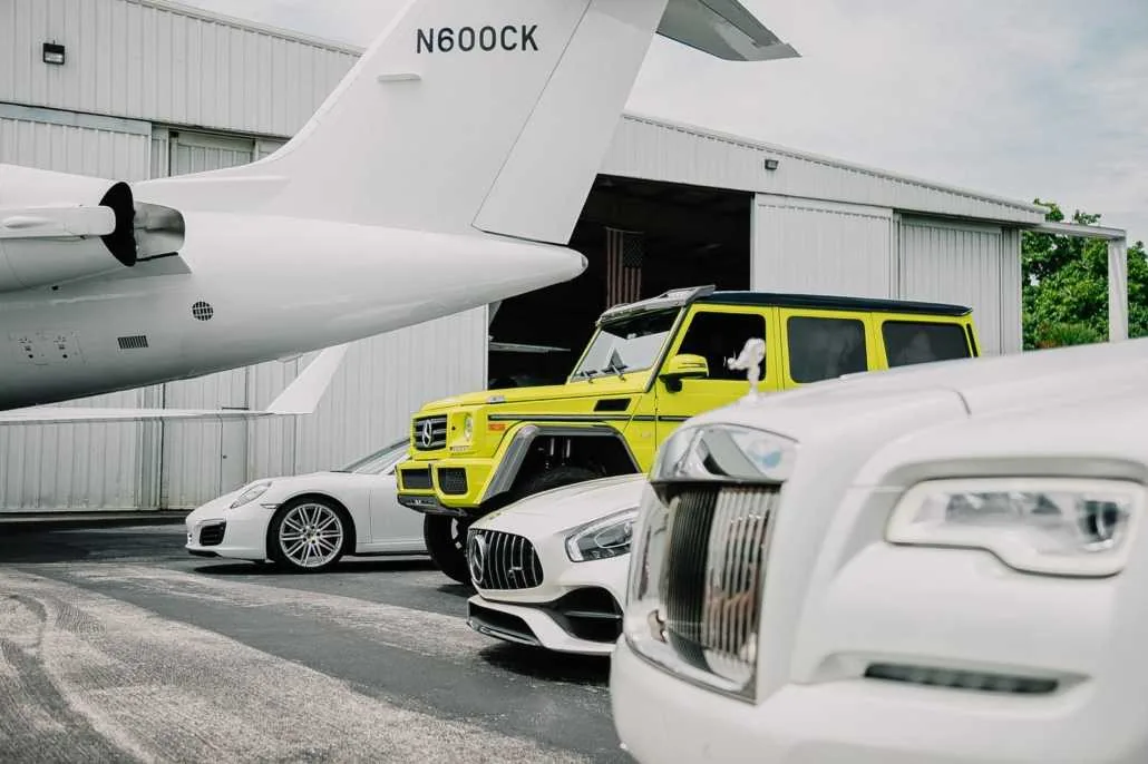 Luxury vehicles beside an aircraft hangar in the Pugachev company archive