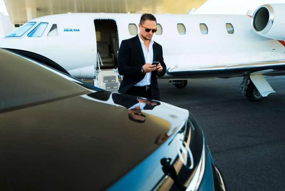 Mark Pugachev beside a vehicle and aircraft in the company archive